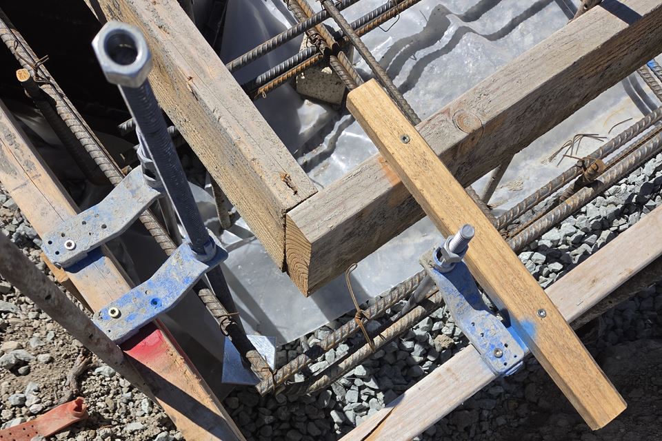Form corner with rebar and anchor hardware, checked before the pour
