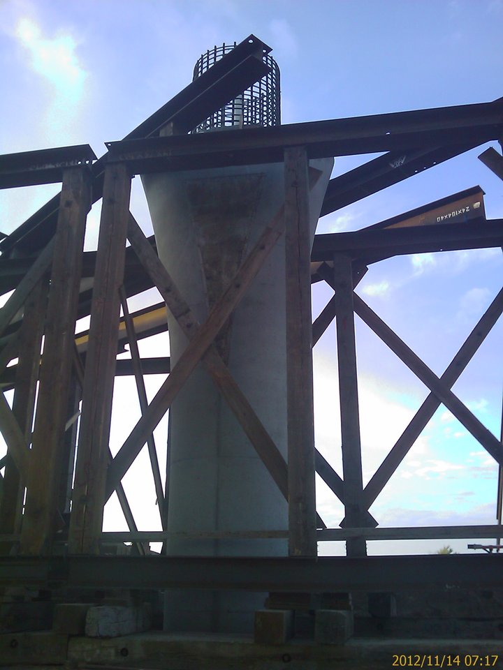 Site photo, 14 November 2012: timber falsework bent built around a new bridge column, X-bracing under a steel cap, stringers stenciled 24x104x40