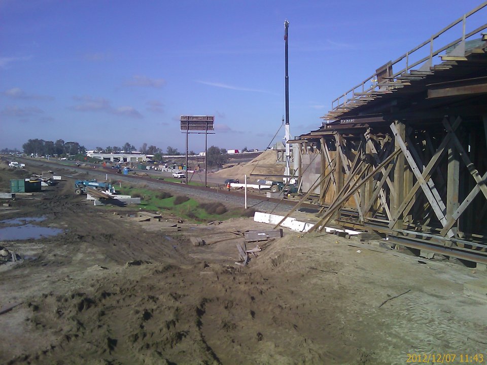 Site photo, 7 December 2012: heavy timber falsework bents with X-bracing along the railroad, steel stringers and timber joists on top