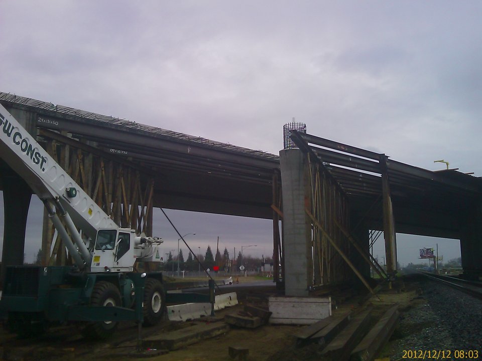 Site photo, 12 December 2012: steel stringers over the railroad beside a new column, with kicker braces at the falsework bent